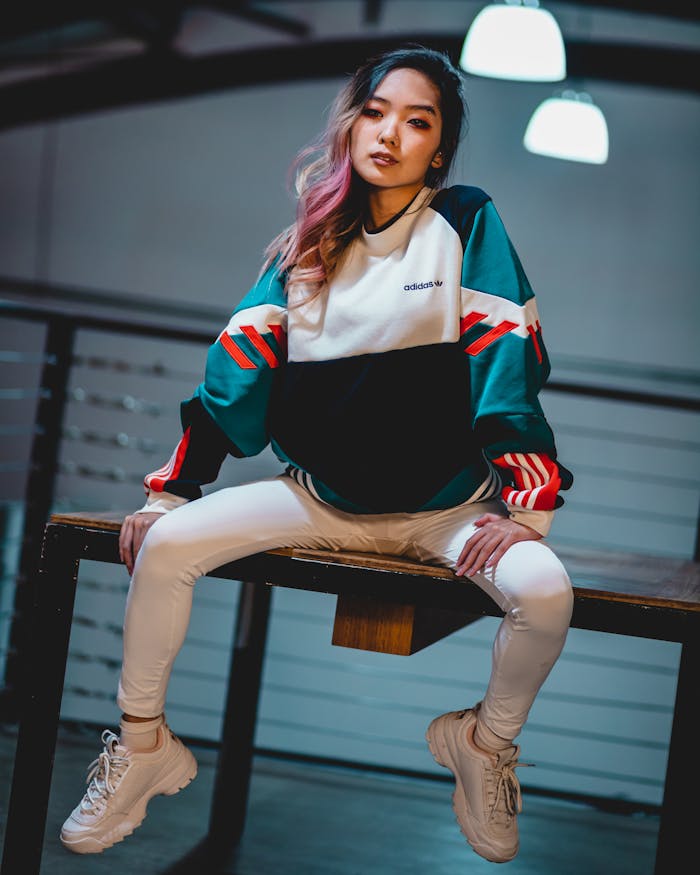 Photo of Woman with Colorful Hair Sitting on Wooden Table Posing